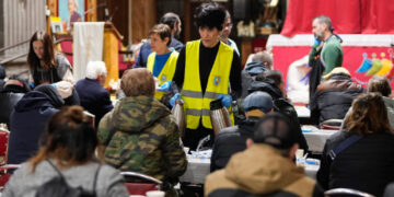 La ministra Elma Saiz se suma al reparto solidario del padre Ángel en San Antón: «Dadles vosotros de comer»