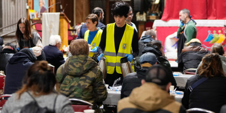 La ministra Elma Saiz se suma al reparto solidario del padre Ángel en San Antón: «Dadles vosotros de comer»